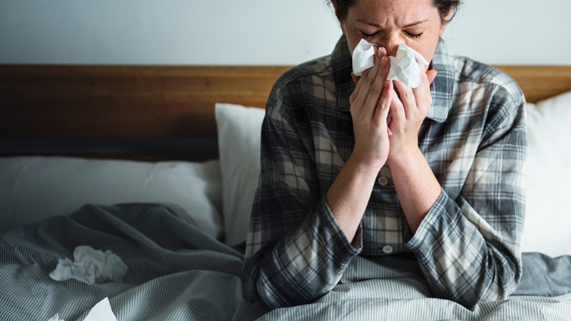 a woman suffering from flu in bed
