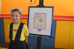 Lucy Thornton standing next to her drawing